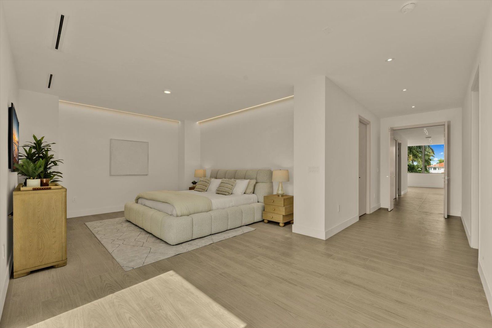 Primary suite with cove lighting and wide-plank floors