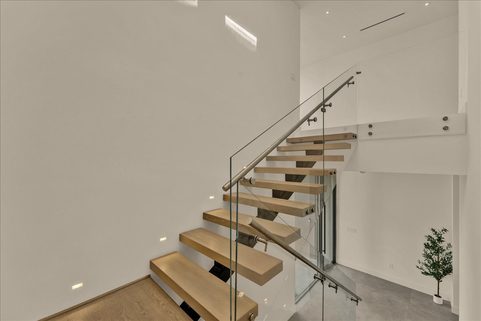 Floating white-oak staircase with glass railing